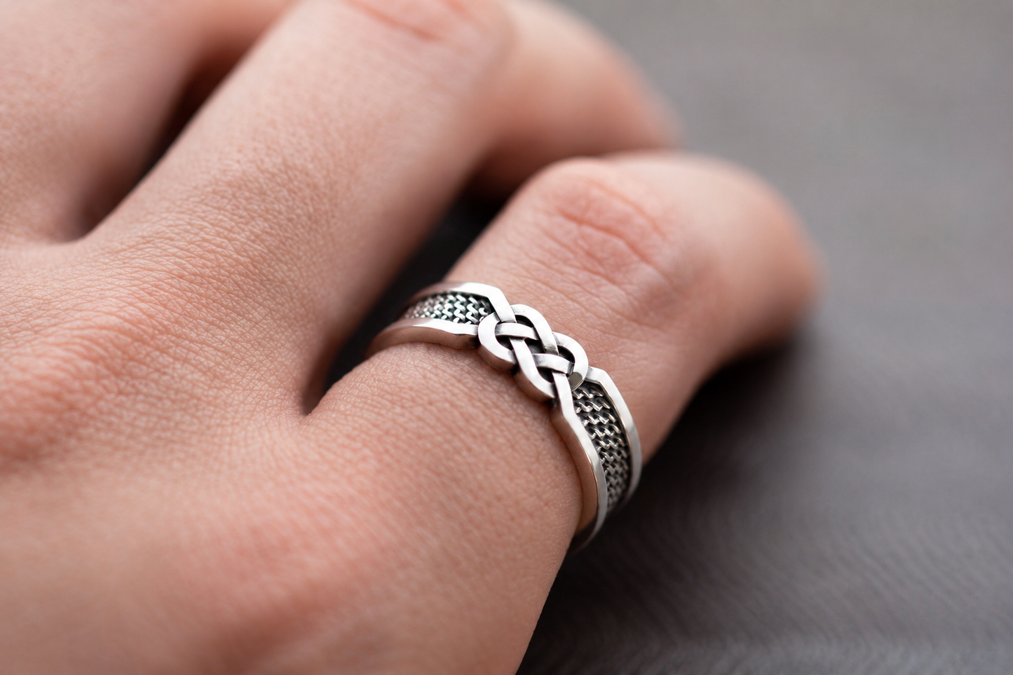 Sterling silver ring with infinity knot design on hand