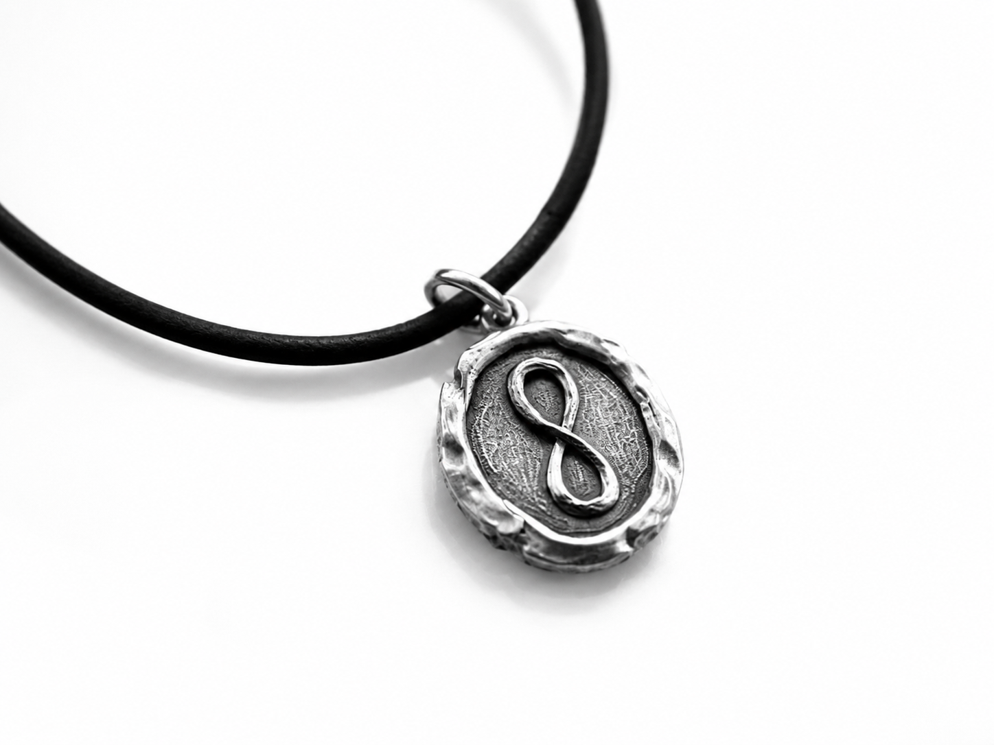 Sterling silver oval pendant with infinity symbol design