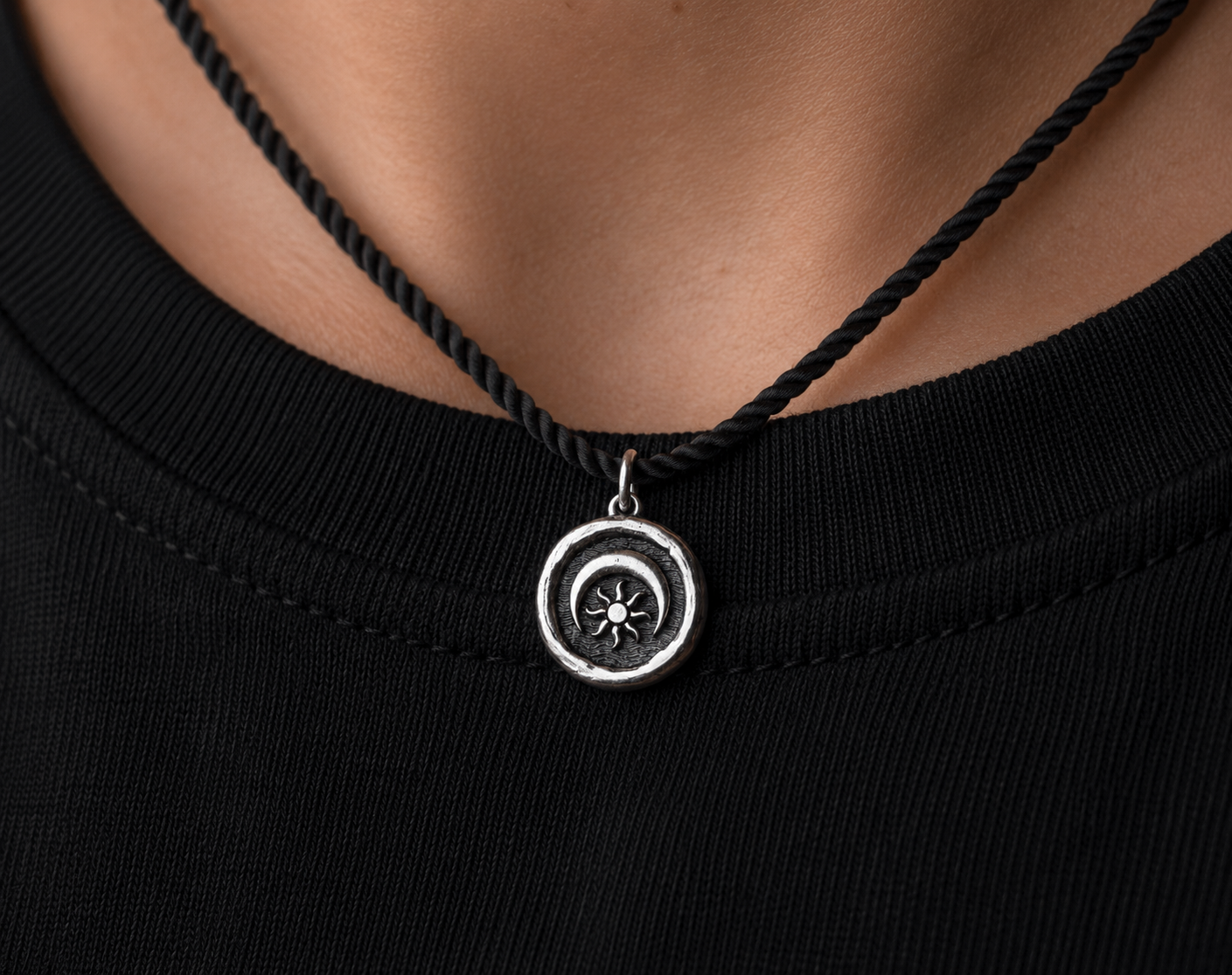 Sterling silver pendant with sun and moon design worn on necklace