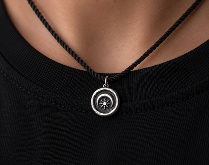 Sterling silver pendant with sun and moon design worn on necklace